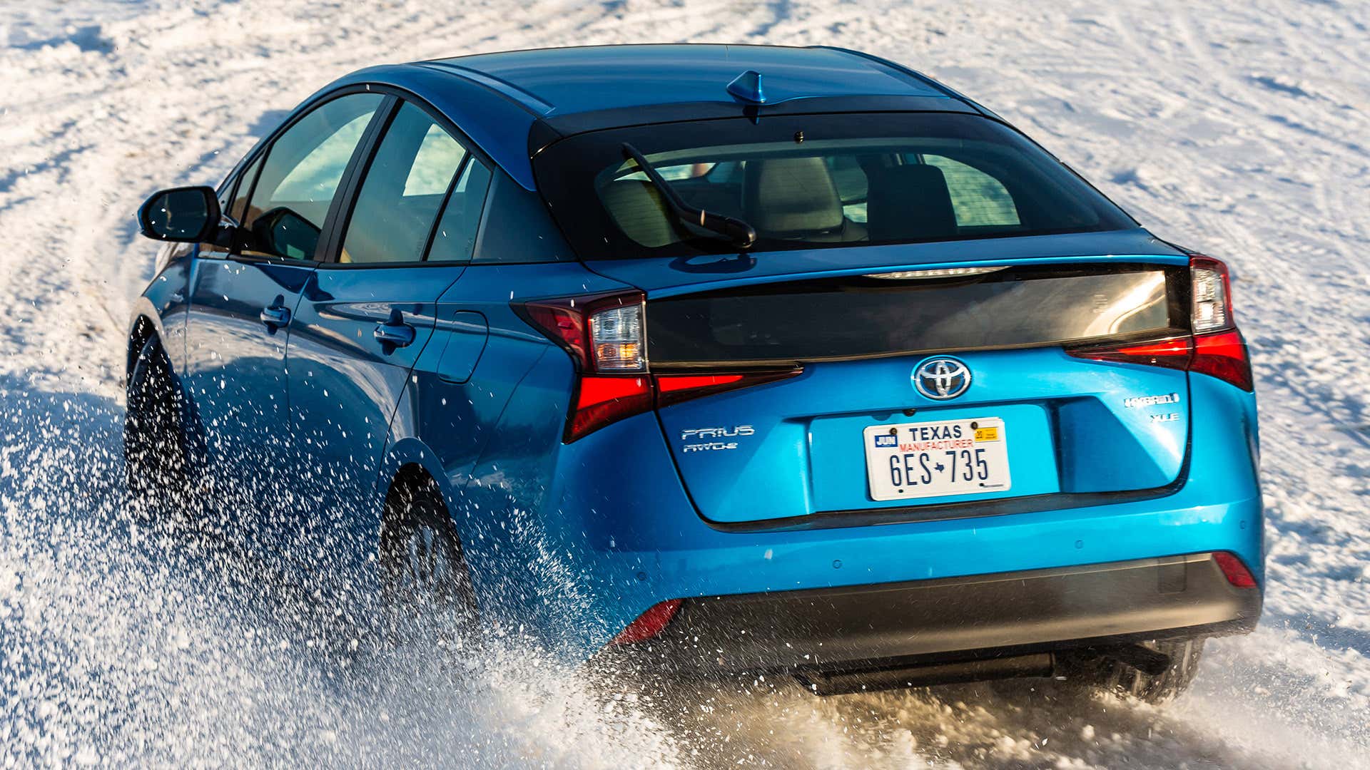 蓝色丰田普锐斯与AWD-e驾驶在白色的雪。