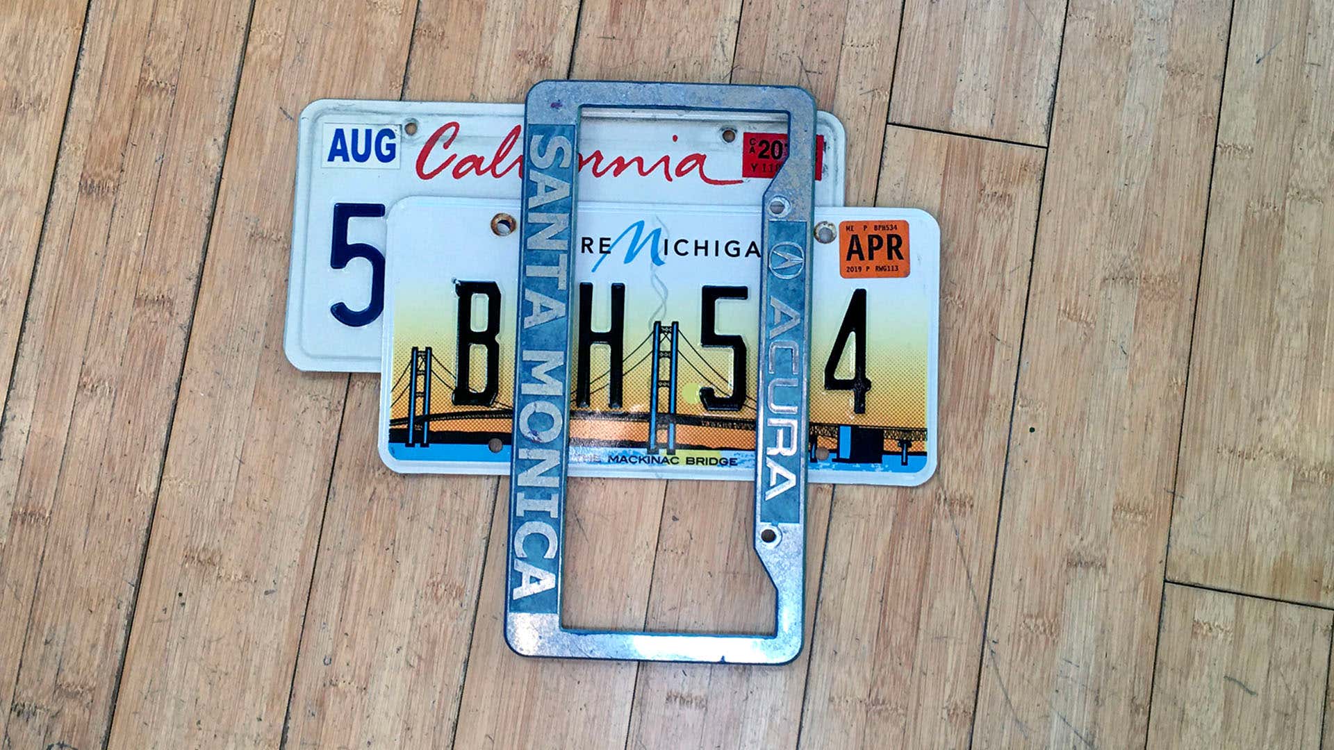 在竹木地板上，密歇根州车牌坐在加州牌照的顶部。