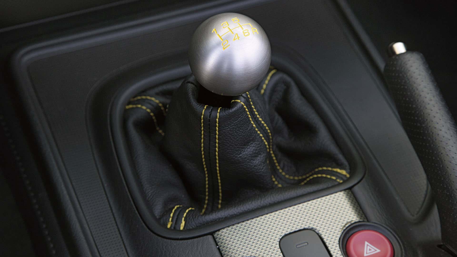 金属球移位器坐在黑色移位靴顶上，用黄色对比度缝合。