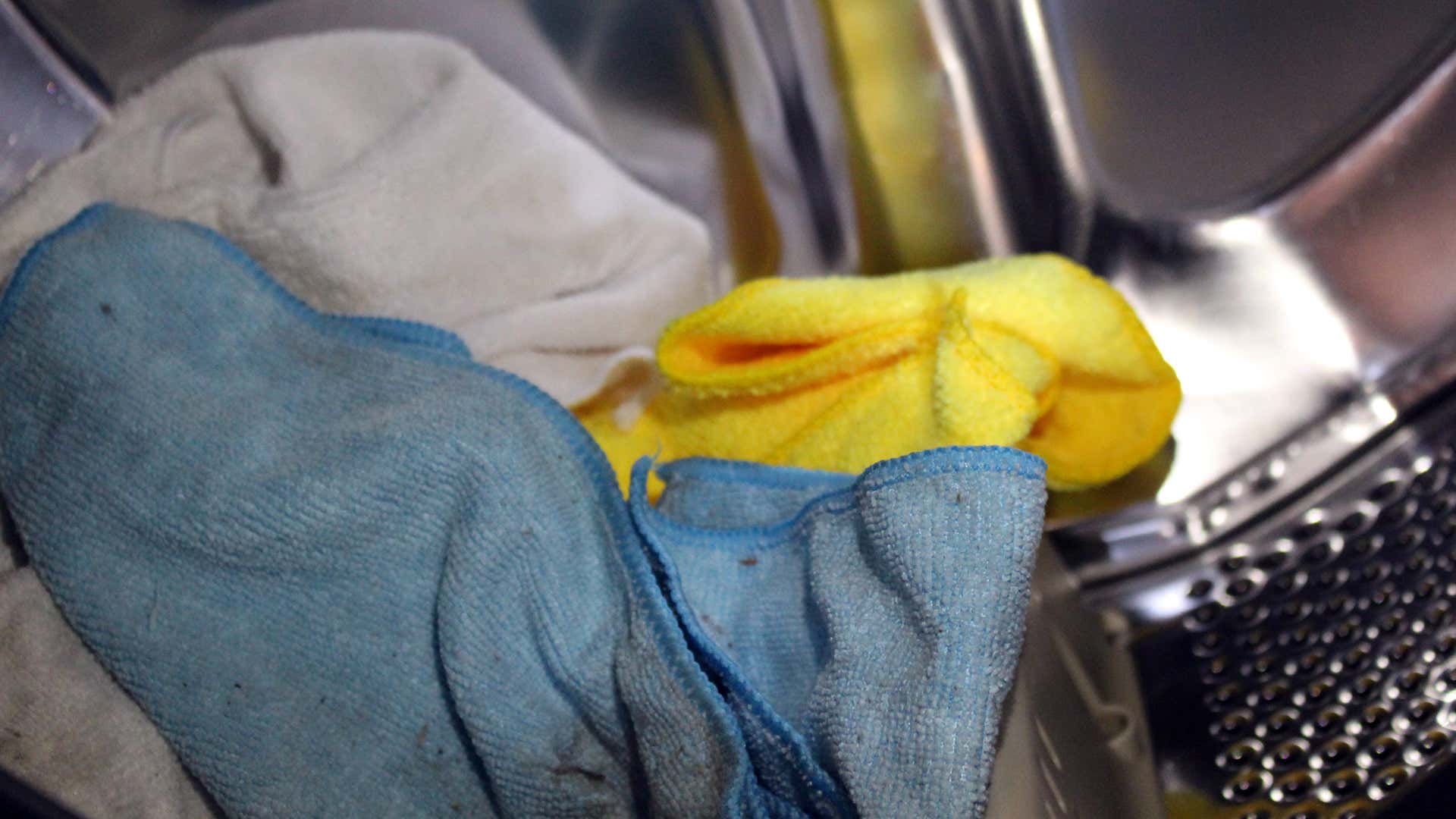 在洗衣机桶中的蓝色，黄色和白色微纤维毛巾。